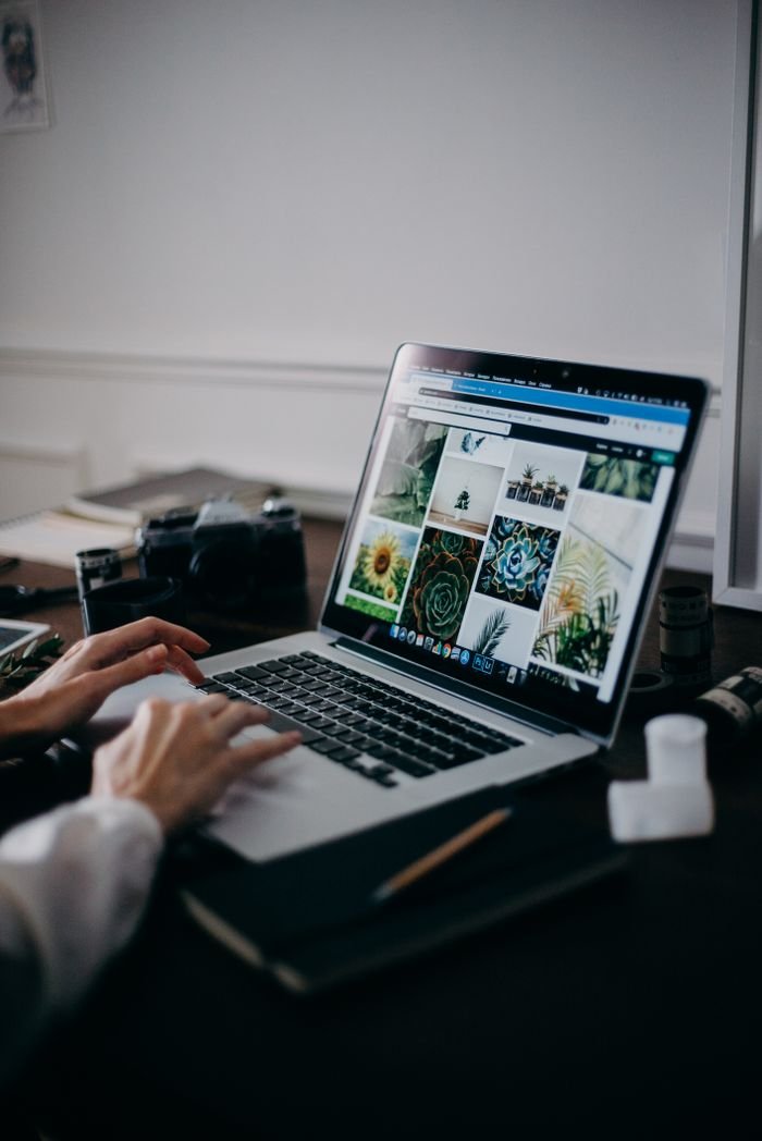Services A creative workspace featuring a laptop displaying a gallery of images, ideal for digital nomads and remote work.